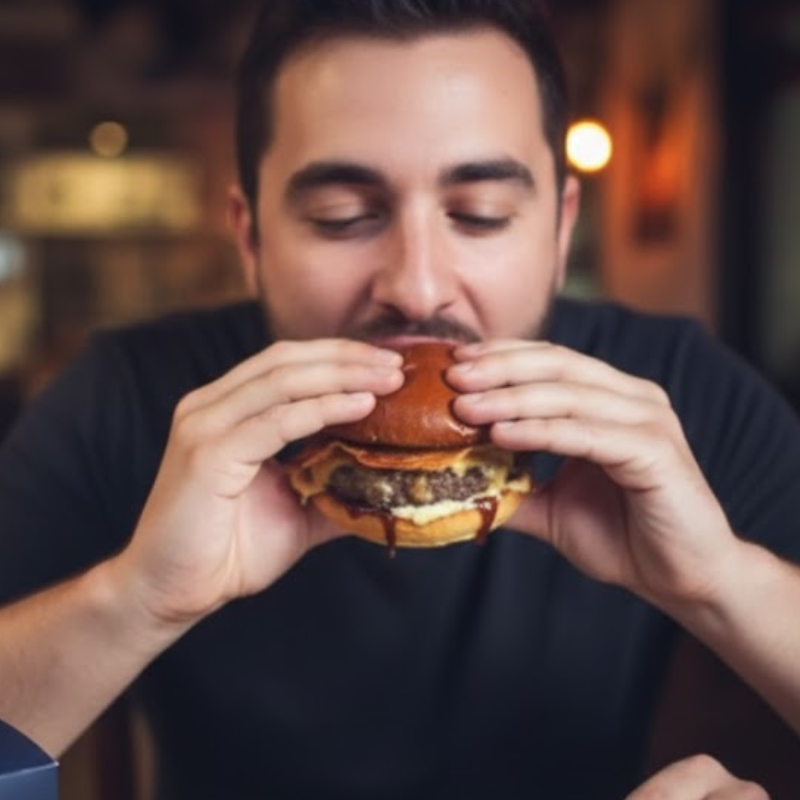hombre comiendo hamburguesas de especialidad en Crítico Restaurante